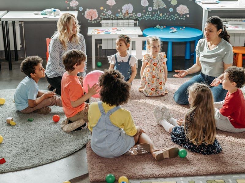 Erzieherinnen im Morgenkreis mit Kindern